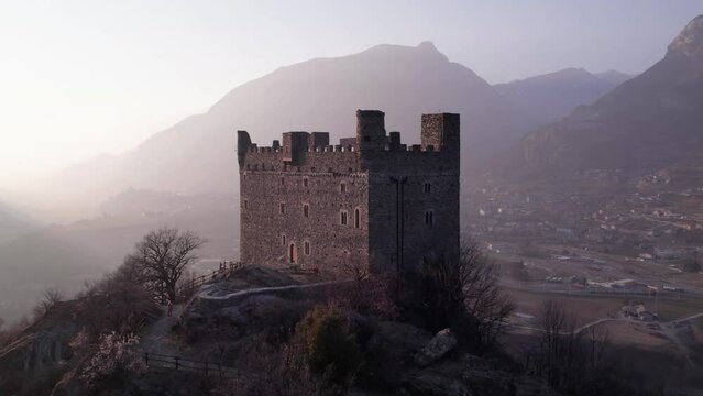 Aerial view flying backwards at Ussel Castle at sunset.