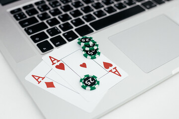 Online casino theme. Playing cards with chips on laptop close-up