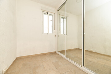 empty room with stoneware floors and a large built-in wardrobe with sliding mirror doors