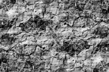 Dark gray rugged surface of abandoned cement plaster wall for texture
