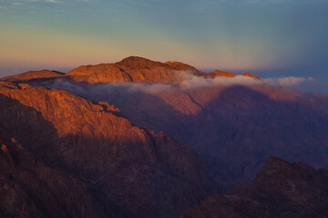 Fototapeta na wymiar Sunrise on the summit of the Holy Mount Moses (Mount Sinai, Mount Horeb or Gabal Musa), Egypt, North Africa. Low exposure 