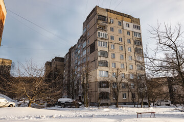 Fototapeta na wymiar Wide shot of soviet-era building in western Ukraine in wintertime with parked car