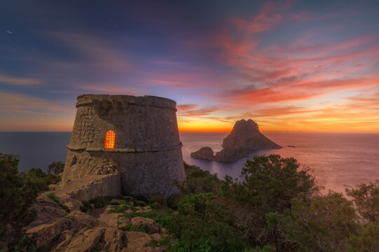 Torre des Savinar and Es Vedra Island , at sunset , with red sky , Ibiza .