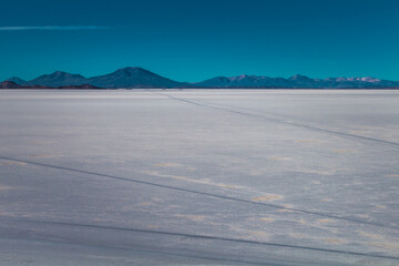 Salt desert with car tire marks running through it - Uyuni Salt Flat