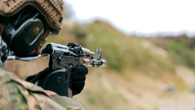 A military soldier aims and fires a machine gun. Military actions on the territory of Ukraine. Russia's war against Ukraine