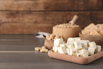 Natural tofu and other soy products on wooden table, space for text