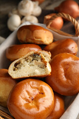 Wicker basket with delicious baked mushrooms and onion pirozhki