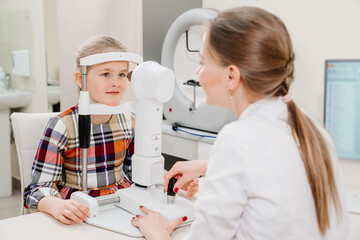 Fototapeta premium ophthalmologist examines the girl on a corneo topographer. modern clinic.