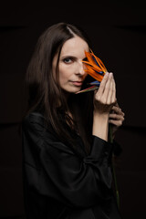 Fototapeta premium Girl with a flower in her hands. Fashion portrait with natural light