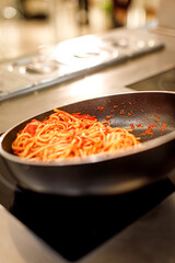 preparazione degli spaghetti  con il sugo in una padella in cucina