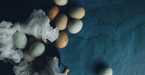 Obraz na płótnie Canvas Top view flat lay of fresh chicken eggs on farm with vintage old texture of dark background.
