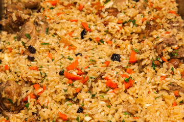 Boiled rice with slices of lamb, carrot, onion, parsley, raisins and garlic. Pilaf, an oriental dish.