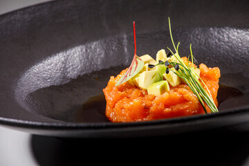 sushi  con salmone servito su un piatto nero  