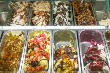 vaschette di gelato ai vari gusti esposte in una gelateria 