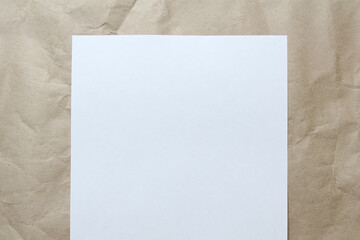 White empty sheet of A4 format on a beige craft paper. Concept of analysis, study, attentive work. Stock photo with empty place for your text and design.