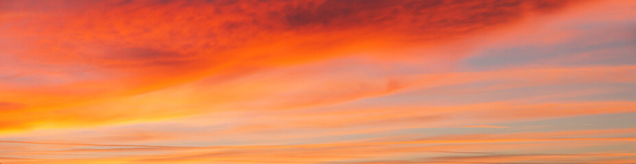 Fototapeta premium Panoramic view of sky with reddish clouds at sunset 