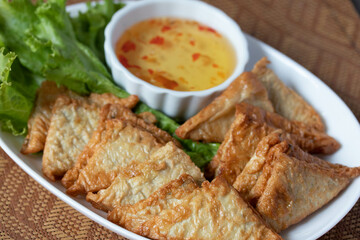 Triangular fried tofu eating with spicy dipping sauce, sweet and spicy