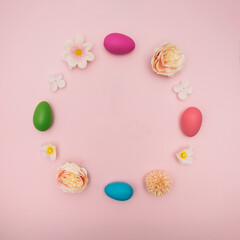 Fototapeta na wymiar Pastel round shape made of Easter eggs and colorful spring flowers on pink background. Trendy minimal concept.