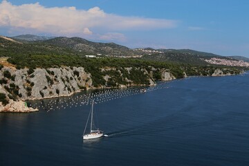 Płynąca żaglówka po rzece na tle gór © Gosia.wuuu