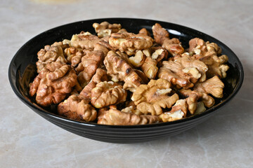 walnuts in a plate, walnut kernels, peeled walnuts.