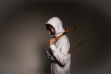portrait of a teenager in a white hoodie with a wooden ball. Back view