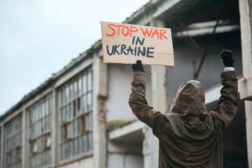 Rear view of protester with 'stop war in Ukraine' message on placard.