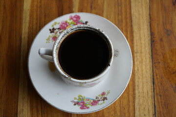a cup of coffee on a wooden table