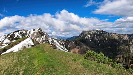 Woman hiking to the Frauenkogel (Dovska Baba) with scenic view on the Karawanks, Carinthia, Austria. Borders Austria, Slovenia, Italy. Triglav National Park. Mount Triglav and Mangart in the back. Awe