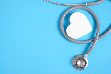 White heart and stethoscope on blue background.Heart disease, medical examination.