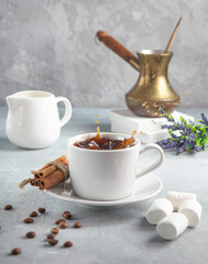 cup of coffee with drops and coffee beans and marshmallow on the table