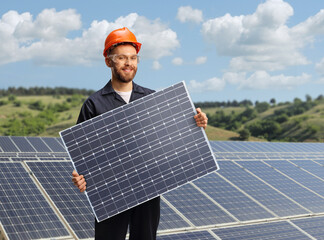 Worker in a unifrom holding a solar cell photovoltaic module