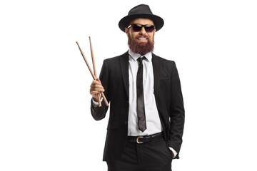 Man in a black suit holding a pair of drumsticks