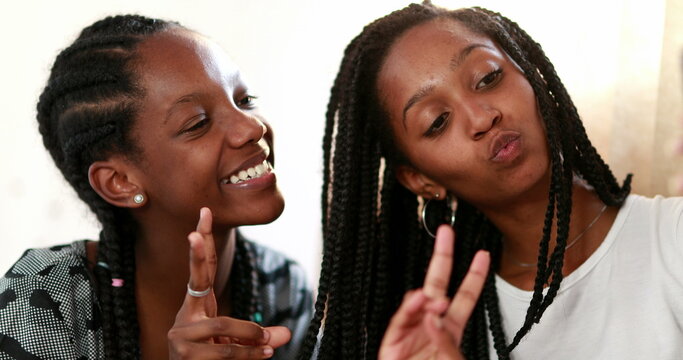 Two teenage black girls taking selfie with smartphone
