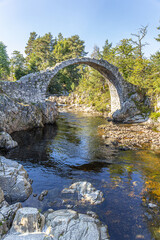 The remains of the Old Packhorse Bridge built in 1717 over the River Dulnain in the village of Carrbridge, Highland, Scotland UK.