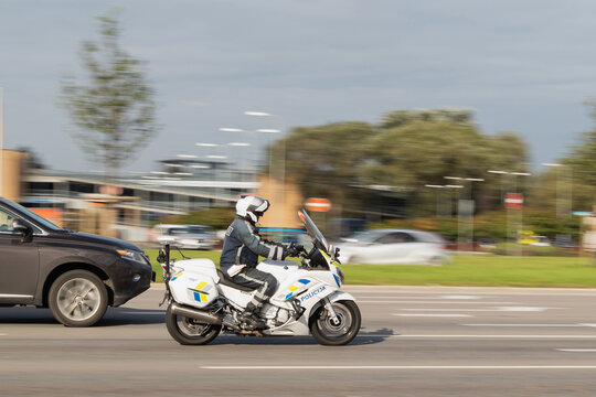 A traffic policeman on a motorcycle is driving down the street. Motion blur. Riga, Latvia - 09 Sep 2021