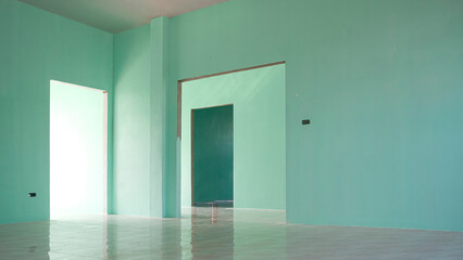 Perspective side view of 3 door frames on green concrete wall with tile floor inside of incomplete...