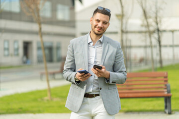 Businessman is smiling while holding his phones