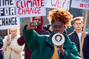 Group Of Protestors With Placards And Megaphone On Demonstration March Against Climate Change