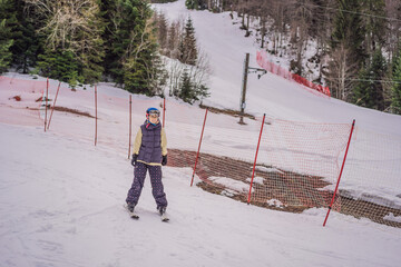 Woman learning to ski. Young woman skiing on a snowy road in the mountains