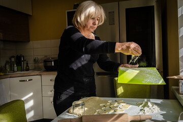 Housewife making dumplings with dough and mashed potato. The process of cooking ukrainian vareniki....