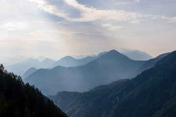 Scenic view on the alpine mountain chains of the Karawanks in Carinthia, Austria. Peaks are shrouded in morning fog. Mystical vibes. Clear and sunny day. Serenity. View from Ferlacher Spitze, Alps