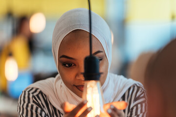 Sentimental portrait of African-American young female Muslim wearing hijab while holding a...