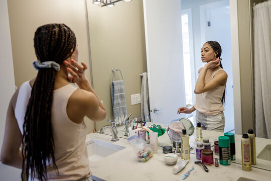 Teenage girl getting ready in bathroom mirror