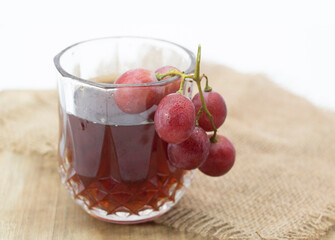 grapes with cup of wine isolated on wooden background