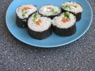 Homemade sushi in a blue plate. Rolls in a plate on the table.