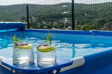 Fototapeta na wymiar Two cocktails on a portable swimming pool