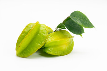 Raw carambolas with green leaves on white background.