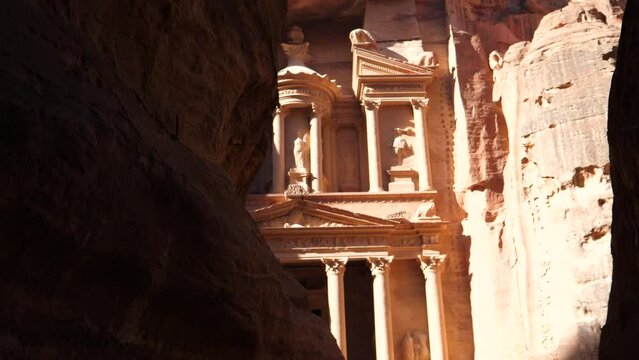 Petra Jordan Sis canion tilt down revealing facade of the Treasury Al Khazna red stone carved ancient city UNESCO world heritage travel destination