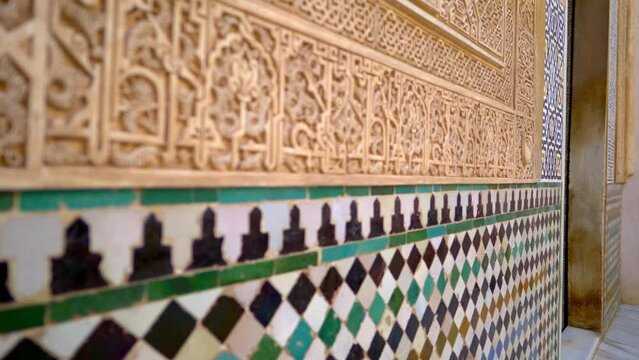 moorish colourful tiles and marble carvings on the walls of historic palace in Andalusia, Spain, antique interior ornament of a traditional Andalusian palace