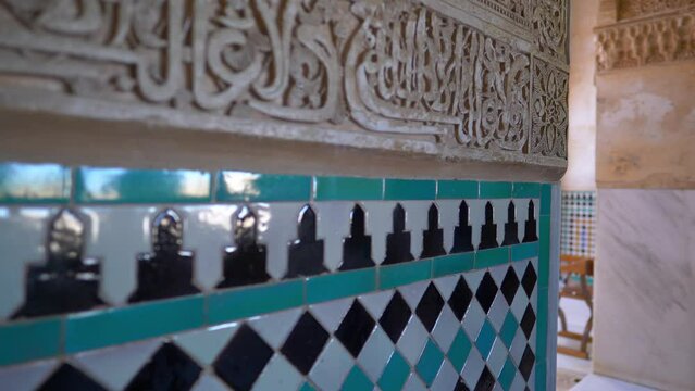 moorish colourful tiles and marble carvings on the walls of historic palace in Andalusia, Spain, antique interior ornament of a traditional Andalusian palace